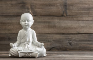 Buddha Figur vor Holzwand