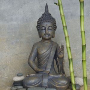 Buddha Dekoideen für das Wohnimmer vor einer grauen Wand