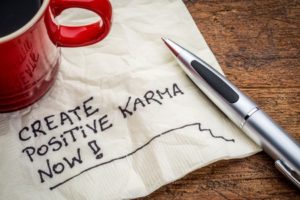 Tasse und Baltt mit Aufschrift Positives Karma jetzt erhalten